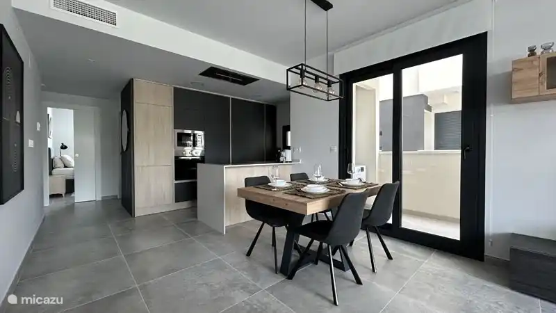 Das geräumige und helle Esszimmer und die Küche mit Schiebetüren an der Seite der Wohnung, die zum zusätzlichen Balkon führen, auf dem sich die Waschmaschine befindet. Auf dem Balkon ist genug Platz für das Trockengestell. 