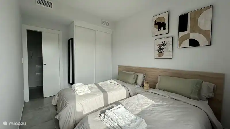 Das Schlafzimmer verfügt über einen geräumigen Kleiderschrank und einen Ganzkörperspiegel. 