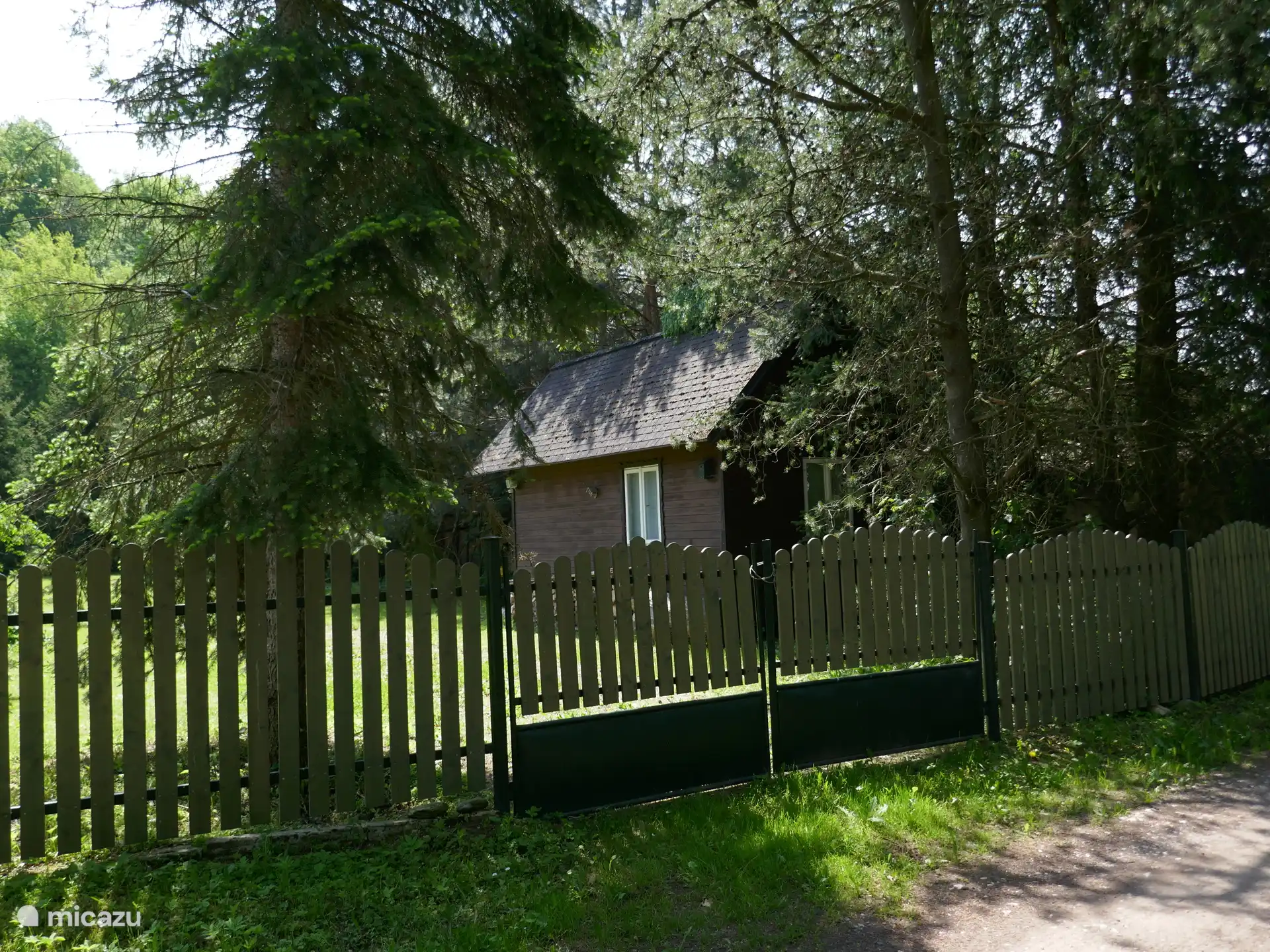 Casa de jardín con plaza de aparcamiento al lado.