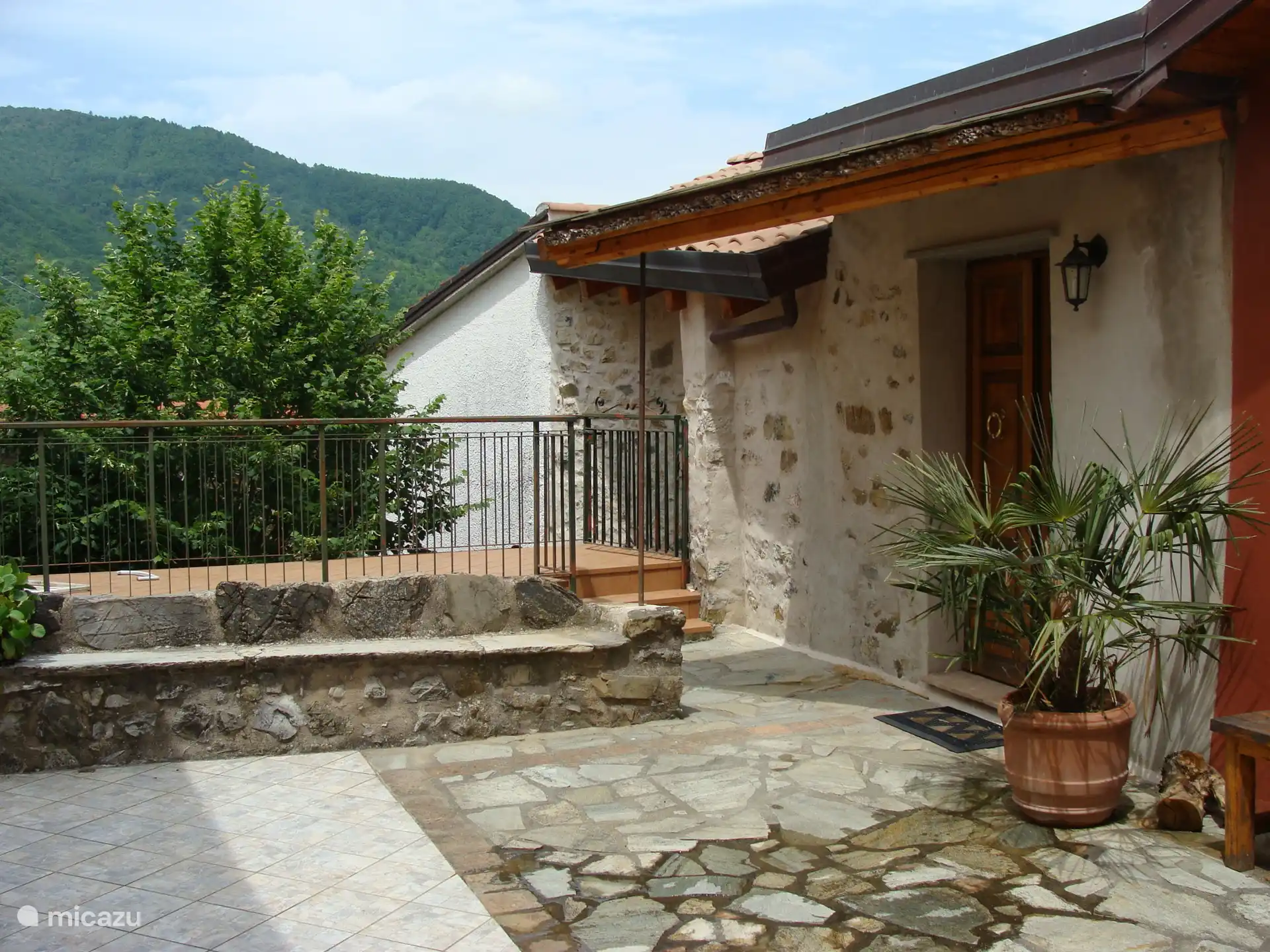 Die Treppe von der Straße führt hinter der Steinbank hinauf