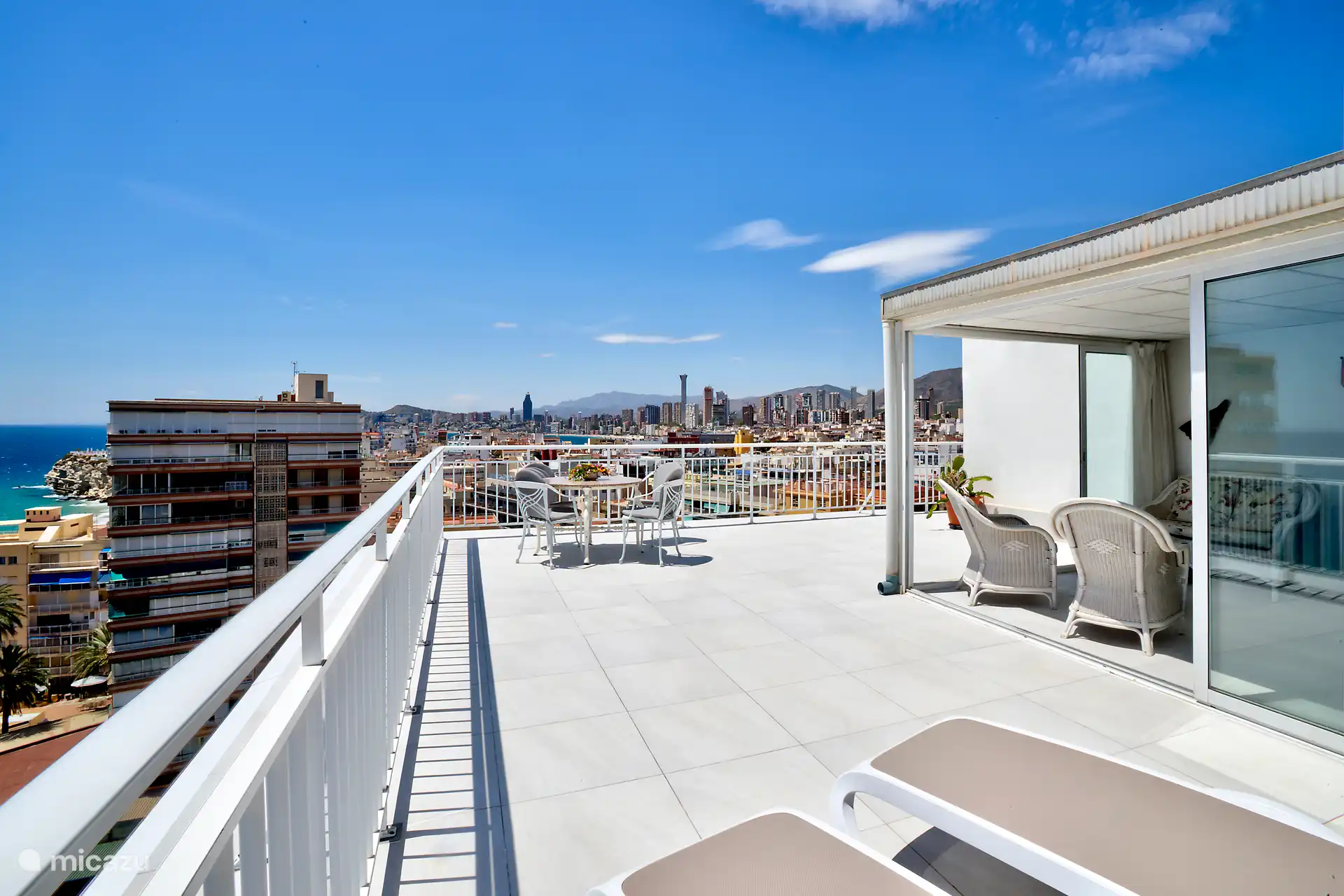 Die vordere Terrasse bei Tag mit seitlichem Blick auf den Wintergarten und die Stadt 