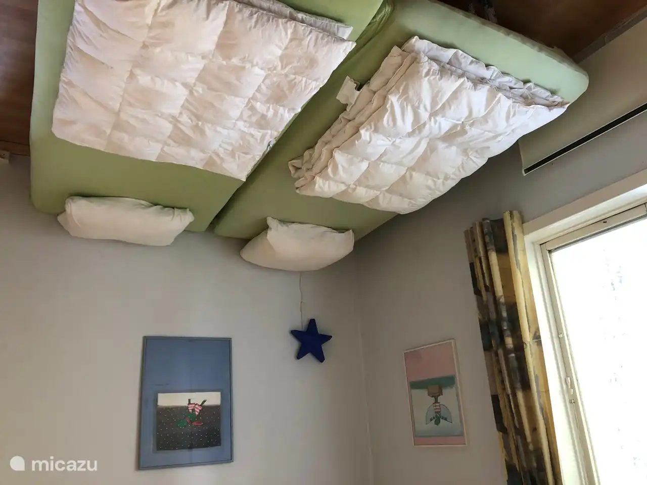 Schlafzimmer 2 im Obergeschoss verfügt über zwei Einbauschränke, zwei normale Betten für Erwachsene, die auch getrennt werden können. Da das Zimmer mit Kinderbuchgemälden und Leselampen für Kinder ausgestattet ist, übernachten die meisten kleinen Gäste in diesem Zimmer.