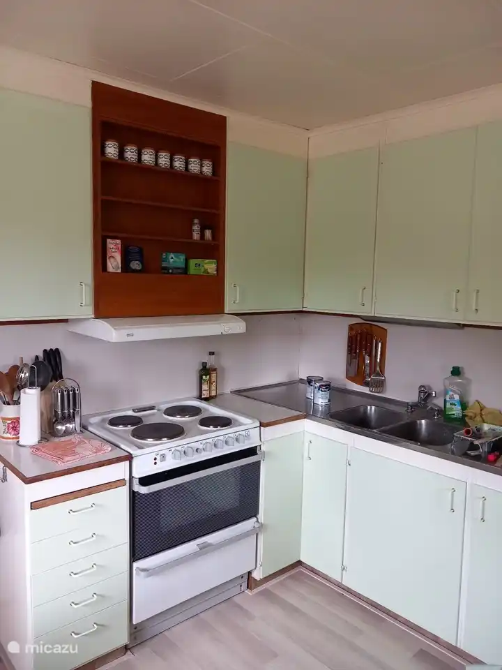 Küche mit vielen Schränken, Backofen, Mikrowelle, Waffeleisen und anderen Geräten