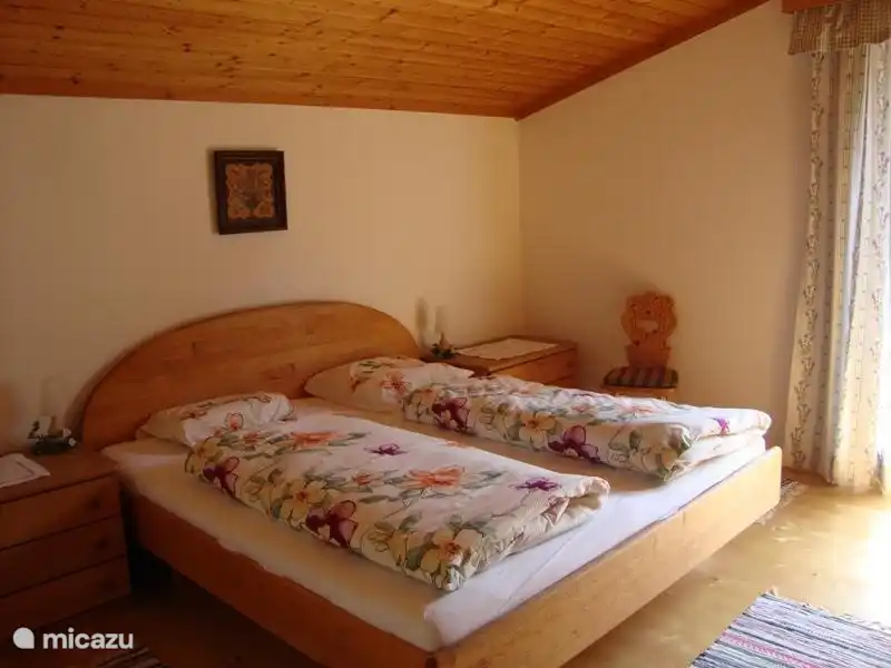 Großes Schlafzimmer, mit schönen breiten Bett mit großen Kleiderschrank und Zugang zum sonnigen Balkon an der Rückseite.