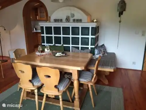 Die gemütliche Sitzecke mit warmen, authentischen Ofen. Vom Sitzbereich hat man einen herrlichen Blick auf die Berge und das Dorf Maria Alm.