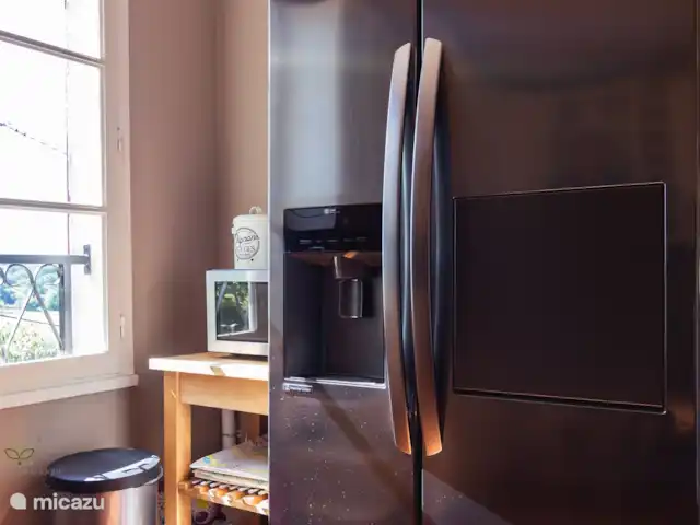 Maison en Dordogne | France, Dordogne, Saint-Sulpice-d'Excideuil - maison de vacances La cuisine avec cheminée, cuisinière à gaz 5 feux, lave-vaisselle, réfrigérateur américain avec machine à glaçons et 2 fauteuils confortables.
