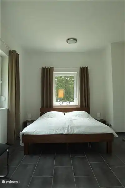 Schlafzimmer im Erdgeschoss des Gebäudes mit angrenzendem Badezimmer.