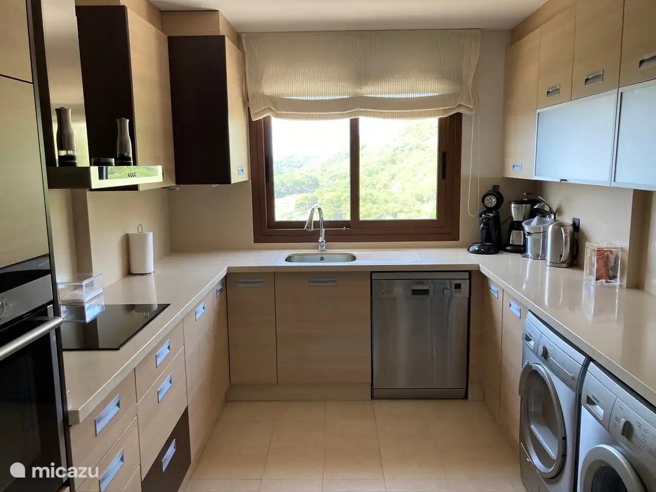 Una gran cocina de lujo con todo el equipamiento necesario, como vitrocerámica, horno, microondas, gran frigorífico-congelador, lavavajillas, lavadora, secadora y cafetera Nespresso.