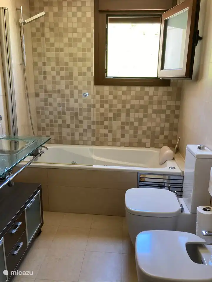 Amplio baño con bañera, lavabo doble, inodoro y bidet.