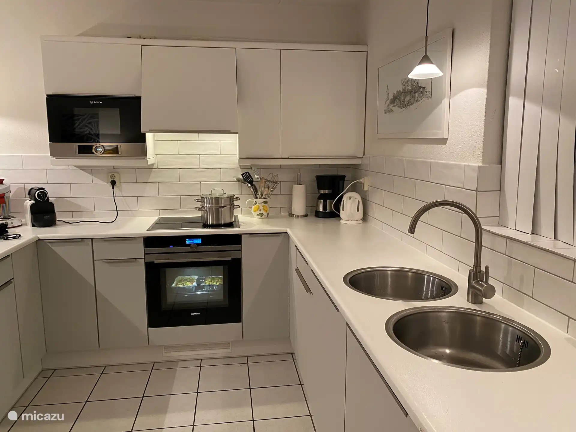 In de open keuken vindt u alle luxe van thuis: inductiekookplaten, magnetron, combi-oven, koelkast met diepvriesgedeelte, een afwasmachine, afzuigkap en een extra boilertje onder het aanrecht voor snel warm water. 