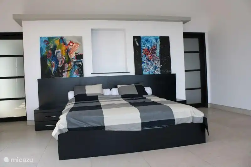 Dies ist eines der 2 Schlafzimmer mit Schiebetüren zum Balkon auf der ersten Etage. Die rechte Tür ist der Eingang und der linke Eingang geht ins Bad. Das Bad ist über die Breite vam das Schlafzimmer.