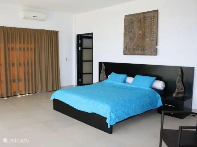Bali Villa Dunia Seni huren in Indonesië, Bali, Bukti - villa Dit is de slaapkamer beneden in de rechter vleugel. Met aan drie kanten openschuivende deuren naar het eigen terras, waar ook nog rustbanken staan. De deaur gaat naar de ruime badkamer.