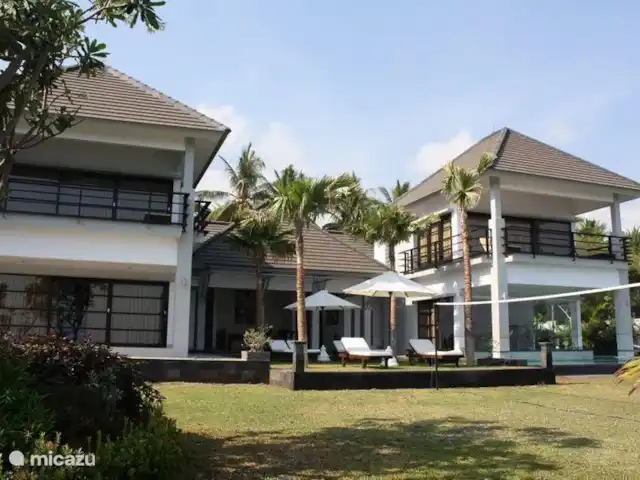 Bali Villa Dunia Seni huren in Indonesië, Bali, Bukti - villa Dit is de zeezijde van het huis. De foto is genomen vanuit het gras gedeelte van de tuin. Duidelijk te zien zijn de twee vleugels. Het overdekte gedeelte in het midden is het terras. Het betreft 1 huis, die in zijn geheel verhuurd wordt.