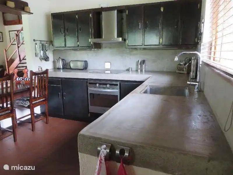 Teil der Küche mit Backofen, Ceranfeld, Dunstabzugshaube und Spüle