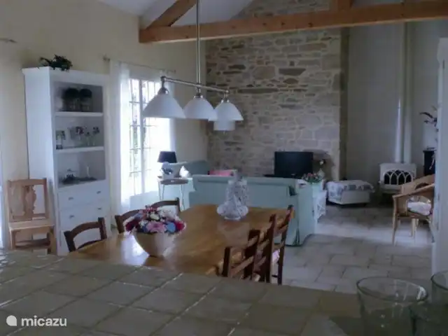 villa huren in Frankrijk, Lot, Sousceyrac – La Tour des Abeilles De grote ruime woonkamer met openslaande deuren naar een groot terras met wijds uitzicht over de groene vallei en het zwembad.