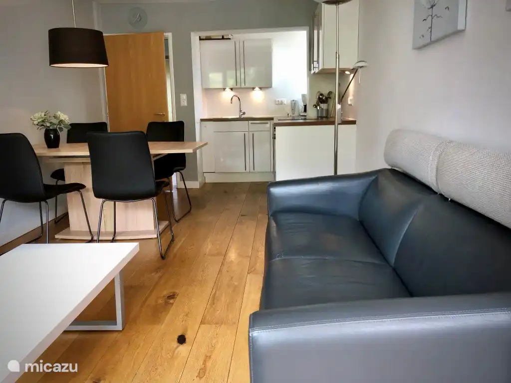 Living area with 2-seater sofa and flat screen.