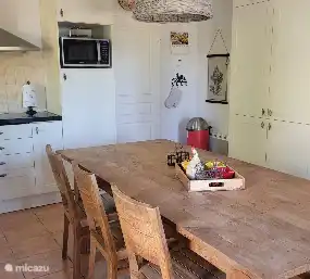 Kitchen with large cupboard. Door to the utility room and behind it the door that gives access to the garage.