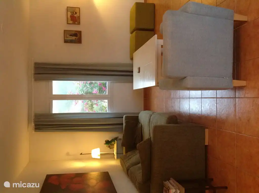 TV room with a bucket, two stools and an armchair.