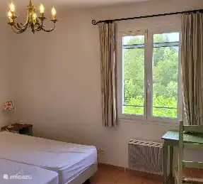 Bedroom 2 upstairs with desk view of the pool, garden and valley. Mosquito nets and air conditioning.