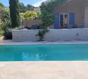 Rear of the villa, to the left a large terrace with lounge sofas.