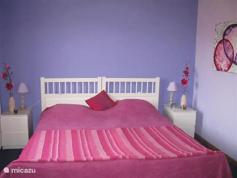 Dormitorio en color Lavanda y Fucsia, con esas lindas camas de nuevo. Junto a un baño.