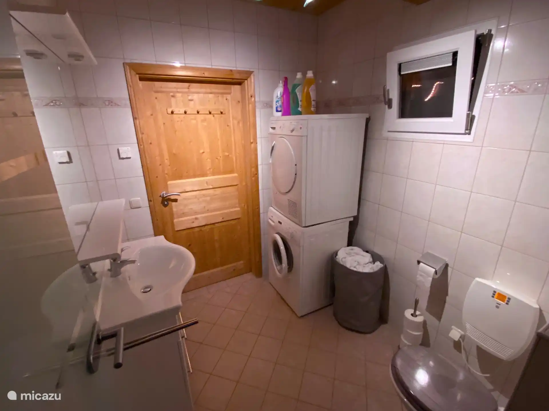 Baño 2 en la planta baja, con inodoro, lavabo y lavadora y secadora. Junto al spa privado.