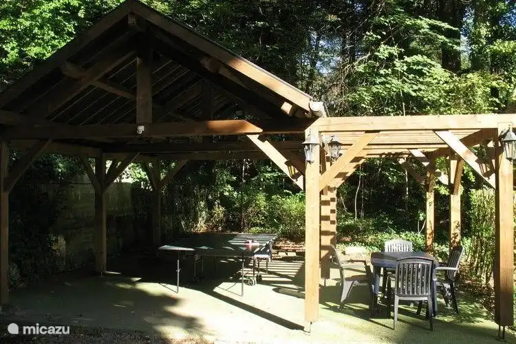 Zurück Veranda im Garten mit Tischtennisplatte und Sitzgelegenheiten.