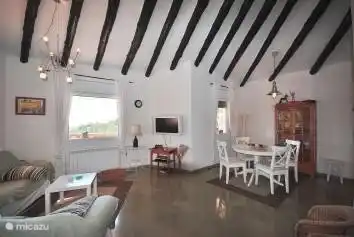 Modern living room with seperate dining kitchen. Living room features a large sofa, flat screen and DVD / CD player.