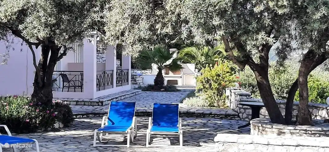 Der paradiesische Garten mit dem schönen Grill mit Küchentheke im Hintergrund.