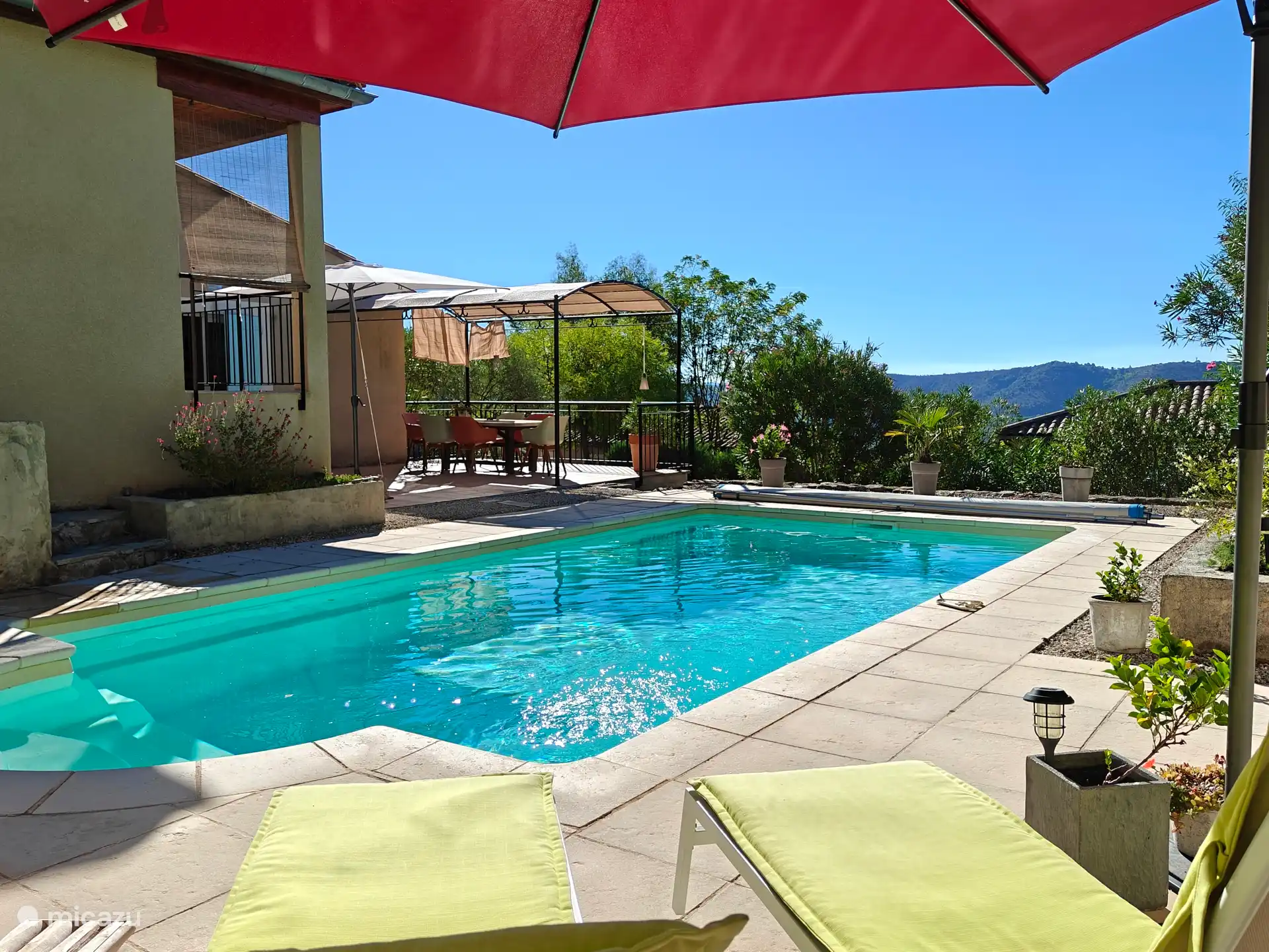 Vue sur la piscine depuis la terrasse ensoleillée.