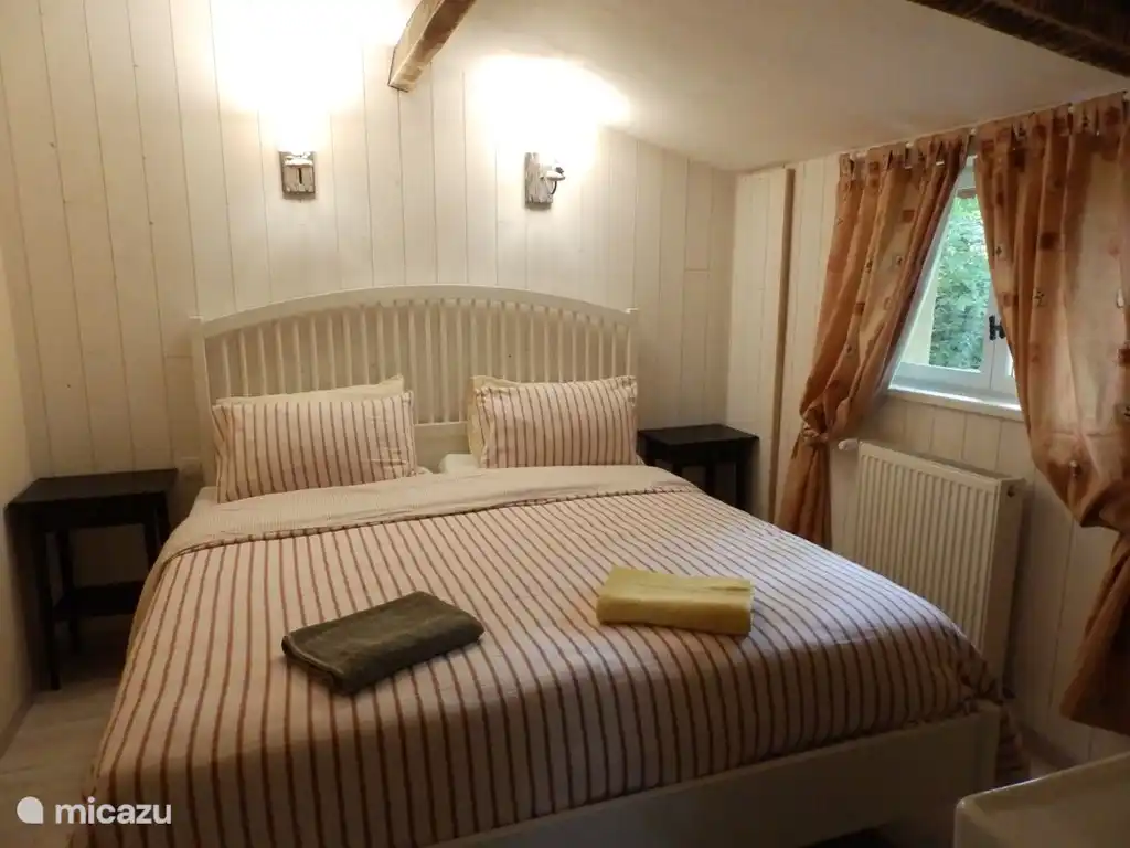 De slaapkamer met wastafel en zicht op de tuin