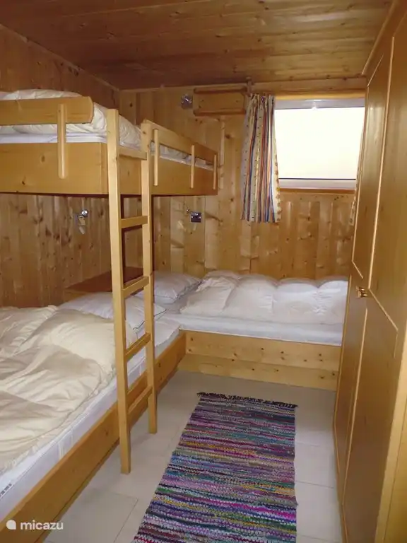 Das dritte Schlafzimmer, ebenfalls mit 3 Betten und einem großen Kleiderschrank. Fliesenboden.