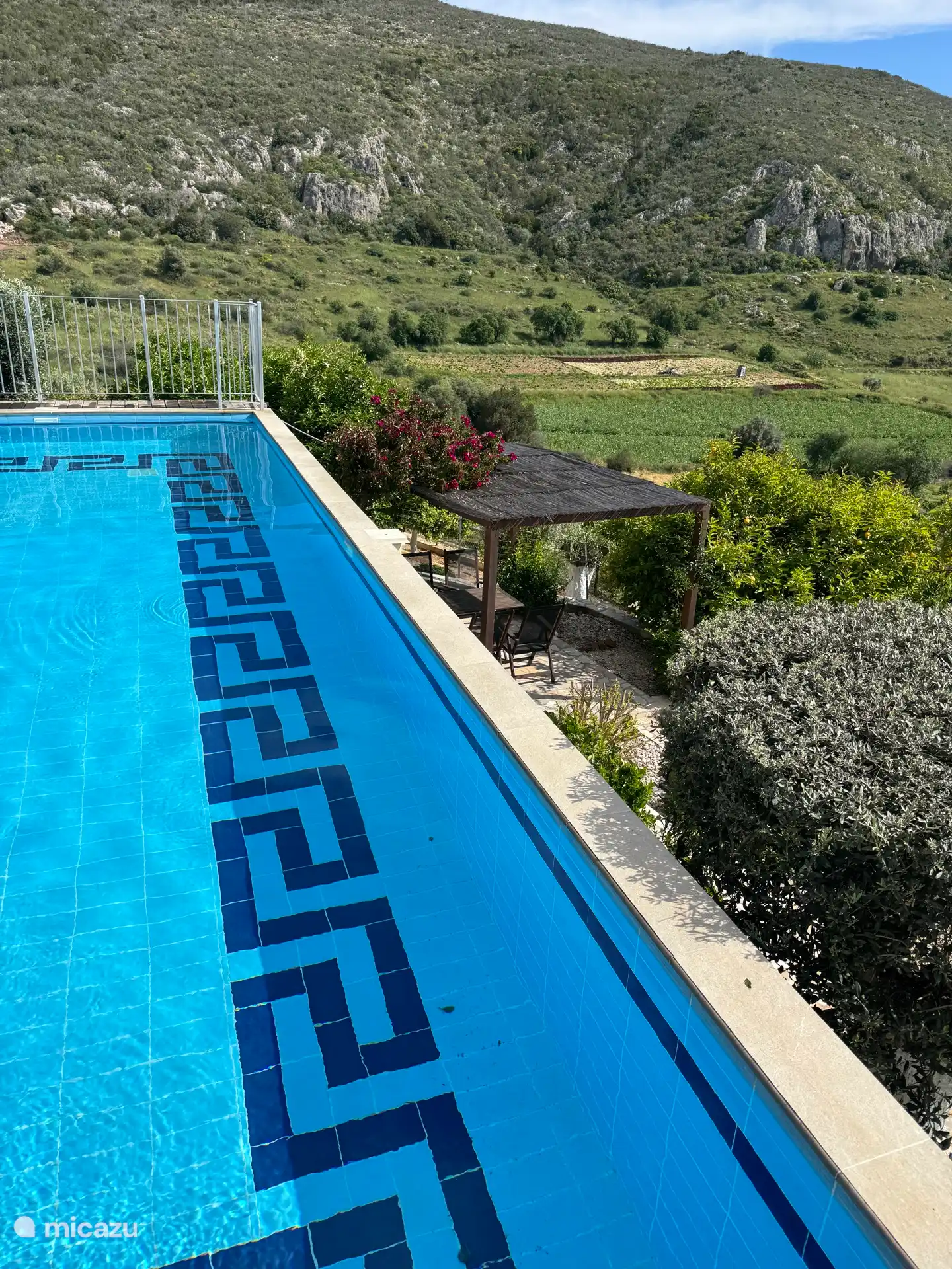 Terrasse mit Sitzgelegenheiten hinter dem Pool 