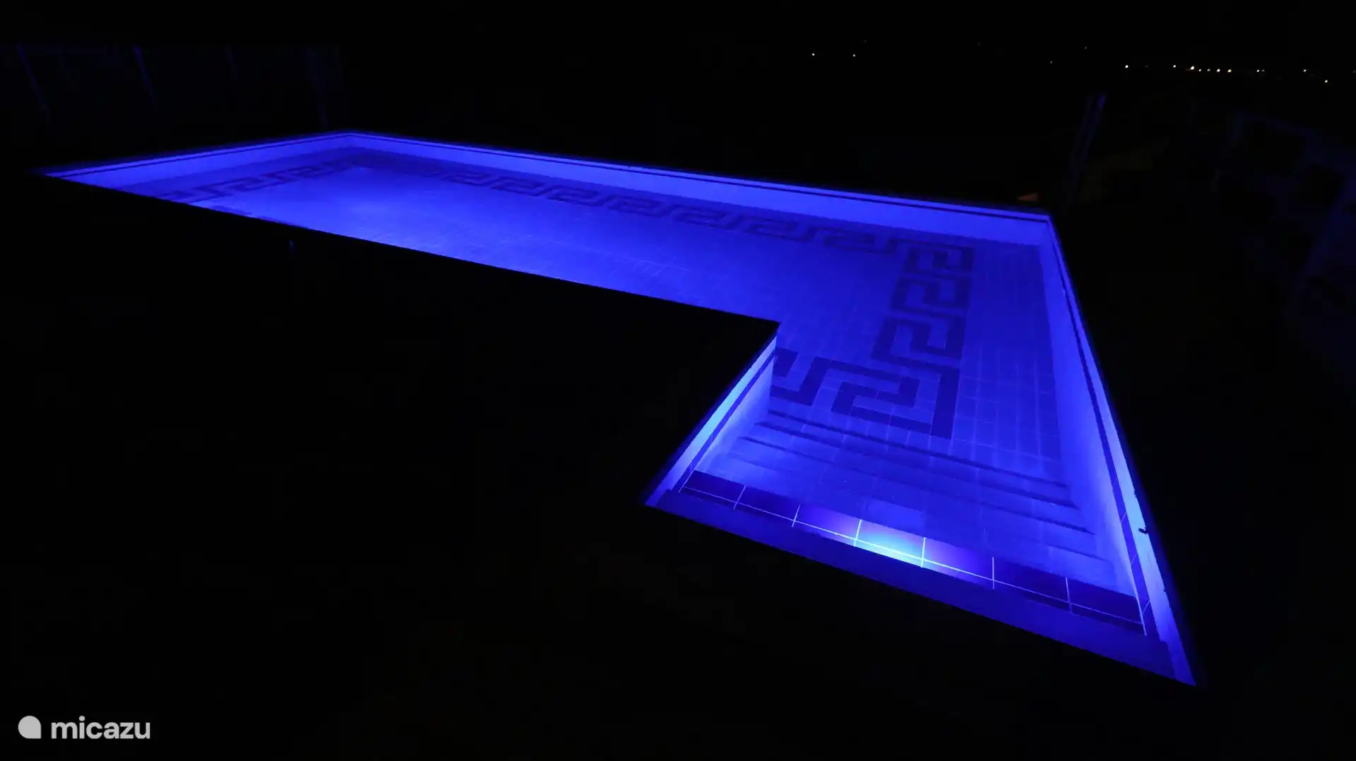 Beleuchtetes Schwimmbad am Abend.