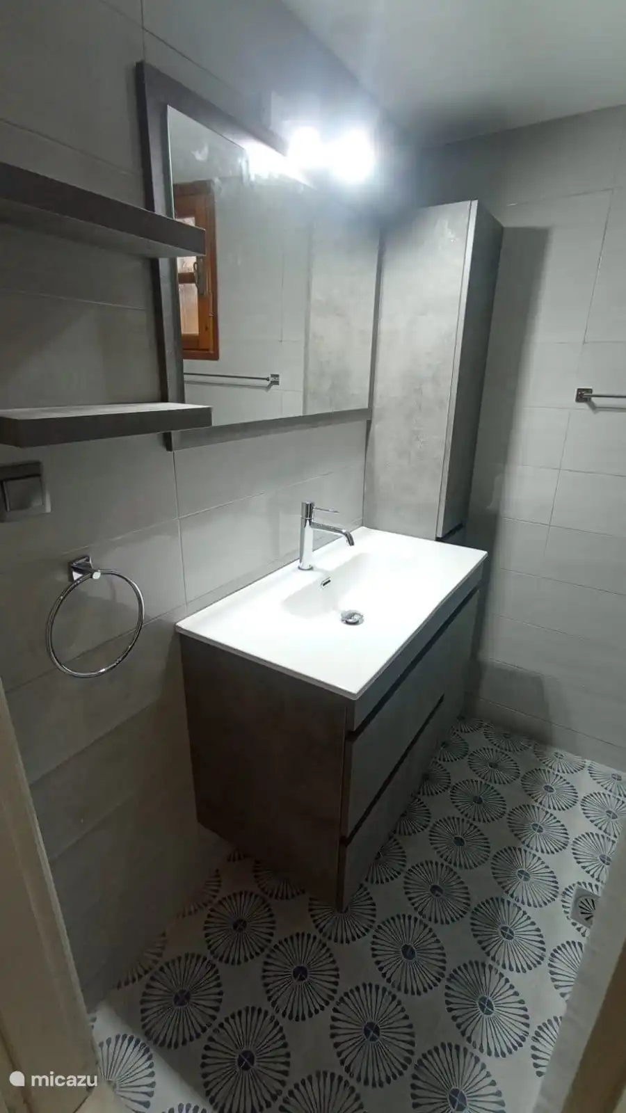 Waschtischunterschrank im neuen Badezimmer mit großem Spiegel und verschiedenen Schränken.