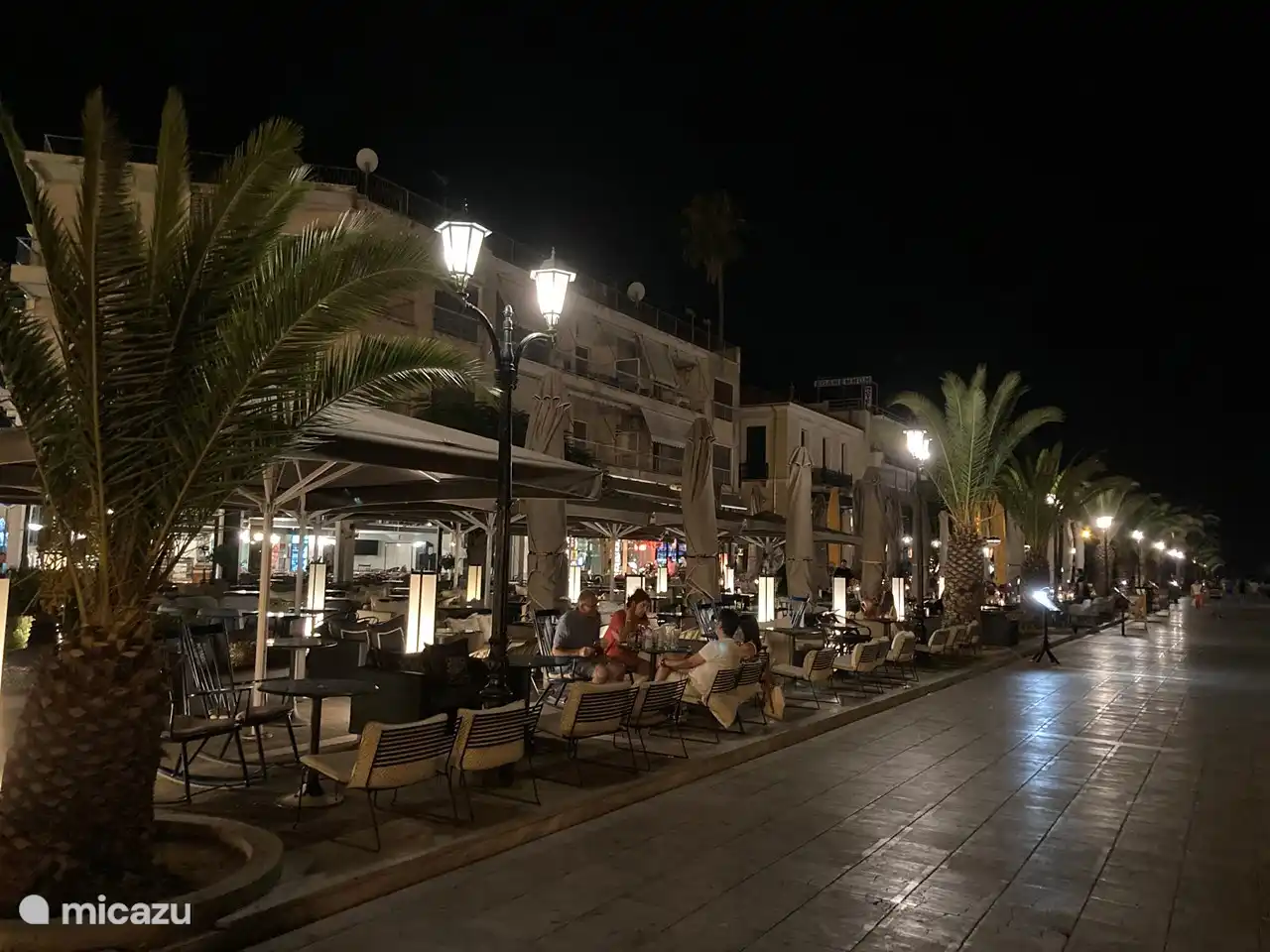 Spaziergang und Kaffee trinken an der schönen Promenade von Nafplio mit Blick auf die kleine Bourtzi-Festung und den Hafen.