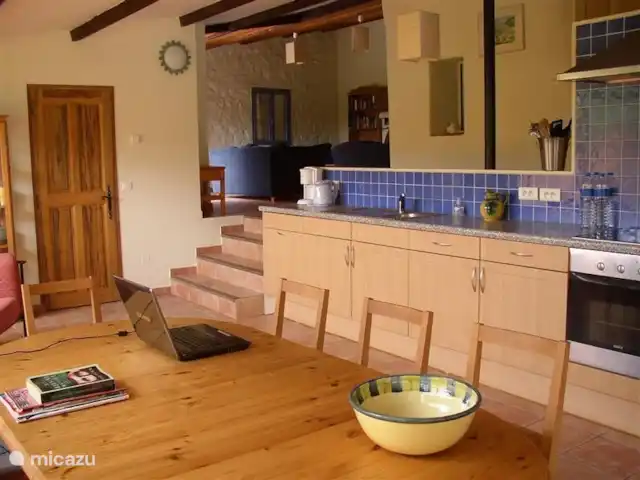 Lei Restanques | France, Var, Carcès - maison de vacances Table de cuisine, évier et en haut des quatre marches le coin salon avec cheminée.
