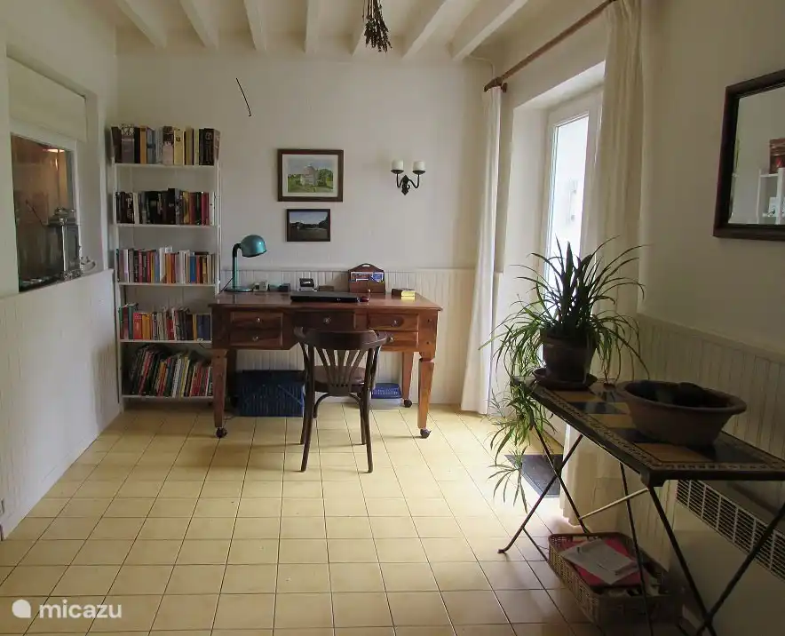 Salle de jardin avec bureau et l’une des bibliothèques. Avec portes-fenêtres donnant sur la terrasse et le jardin.