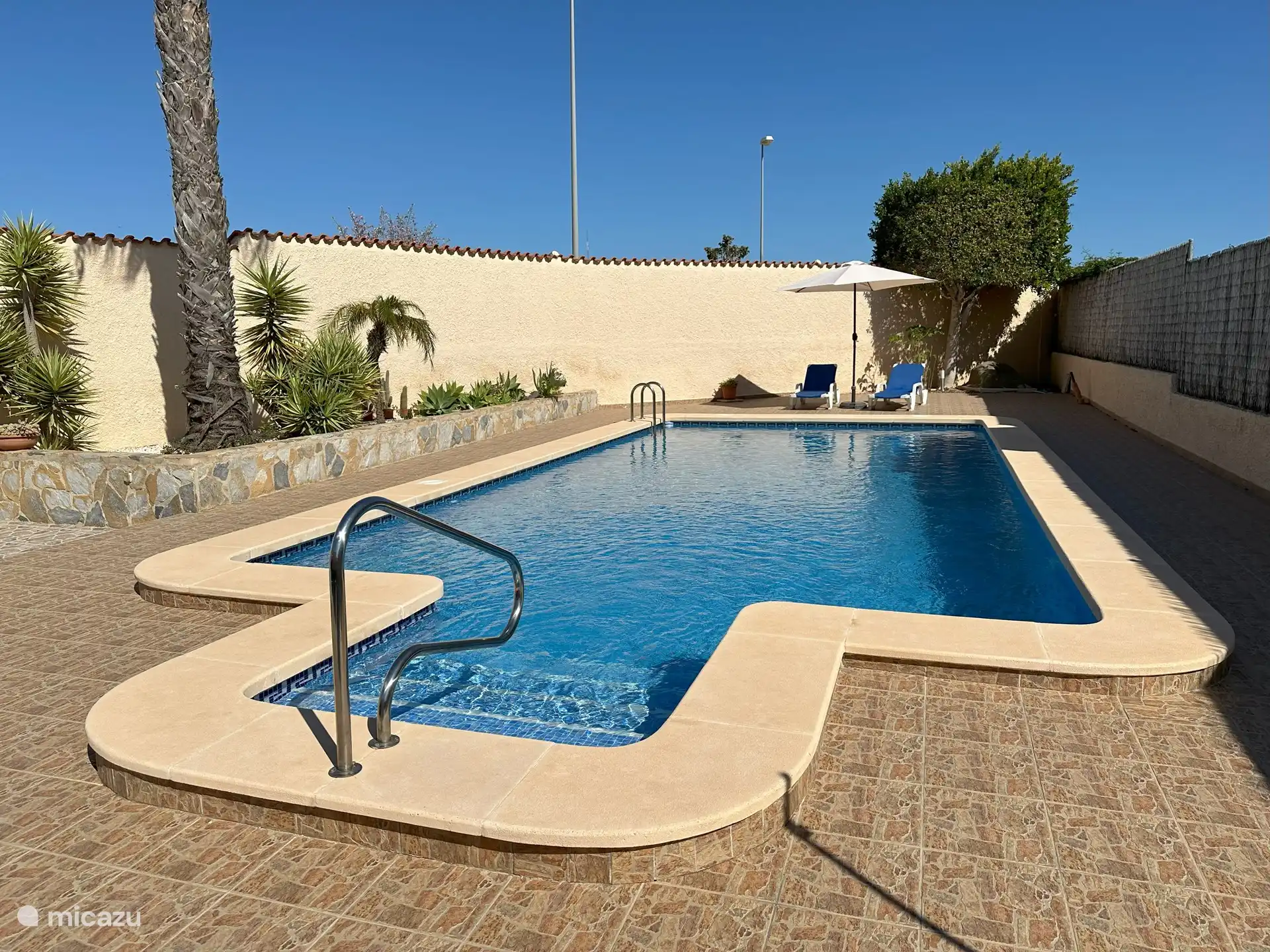 Pool mit Sonnenliegen.