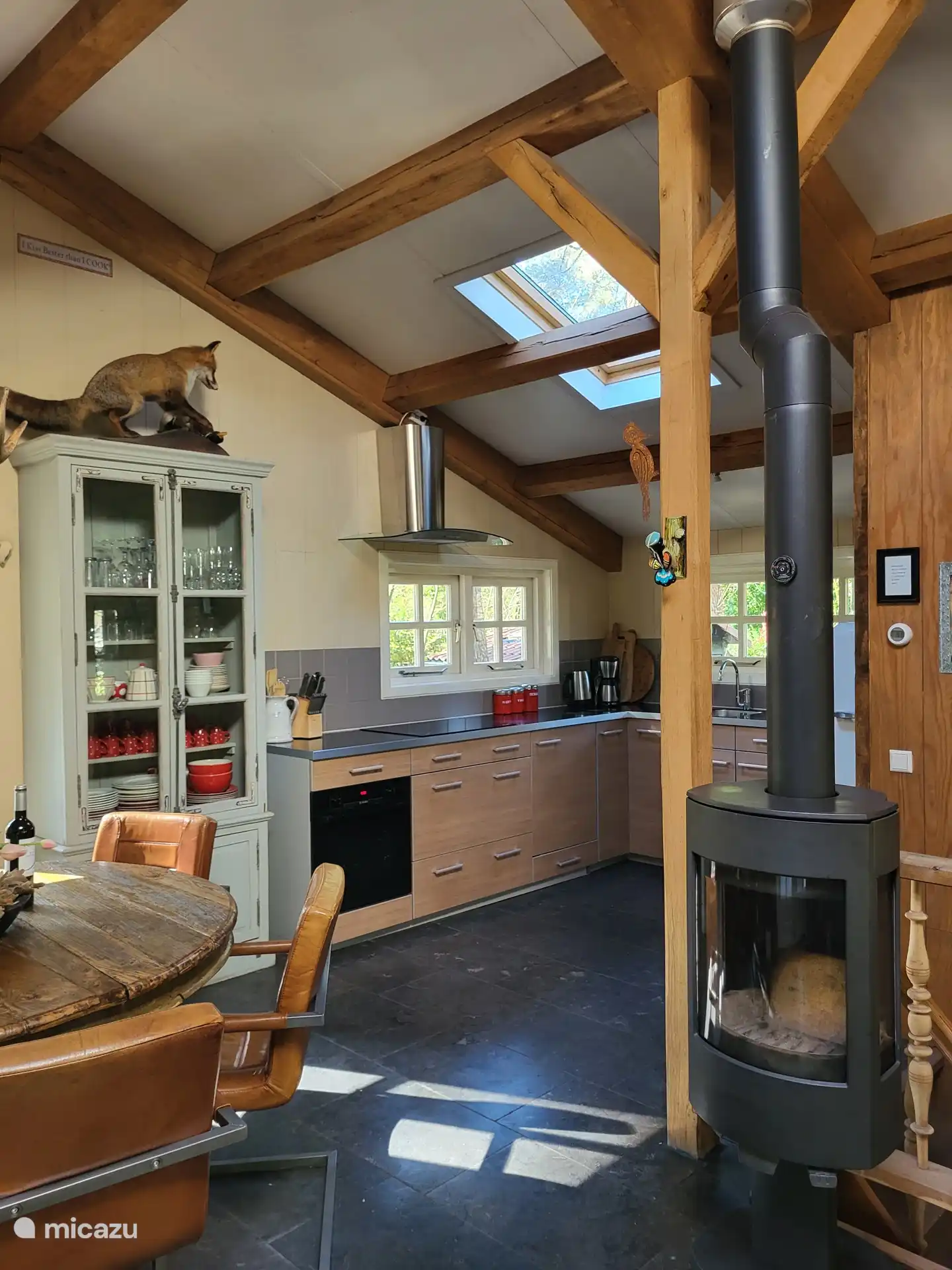 woonkamer met open keuken en houtkachel