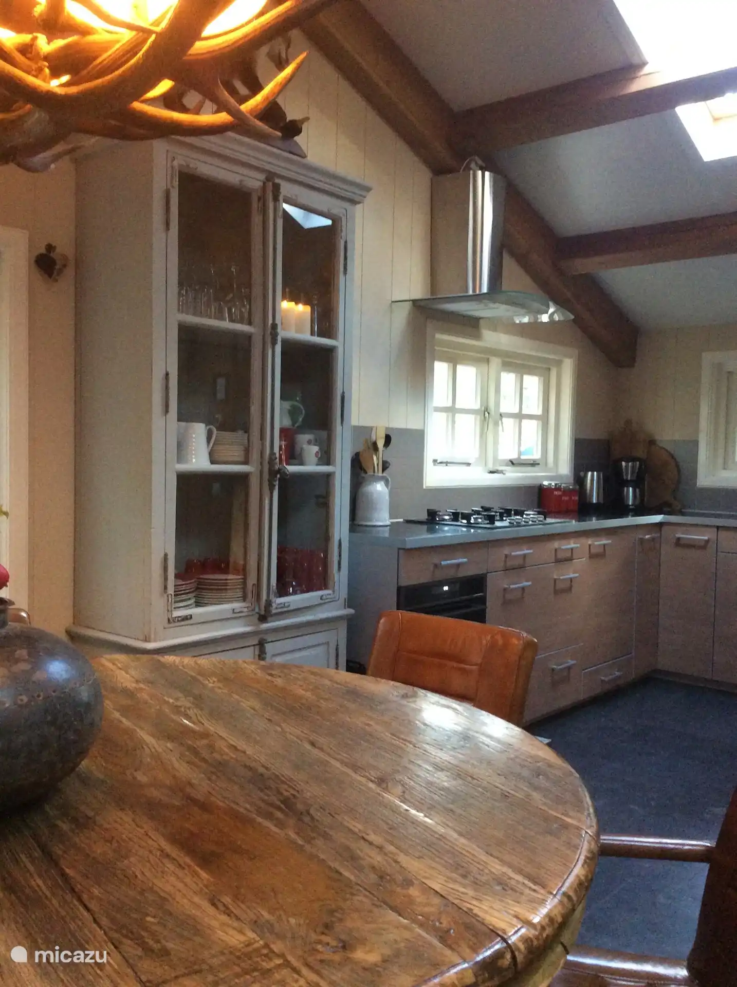 De eettafel en de open keuken met oven en vaatwasser.