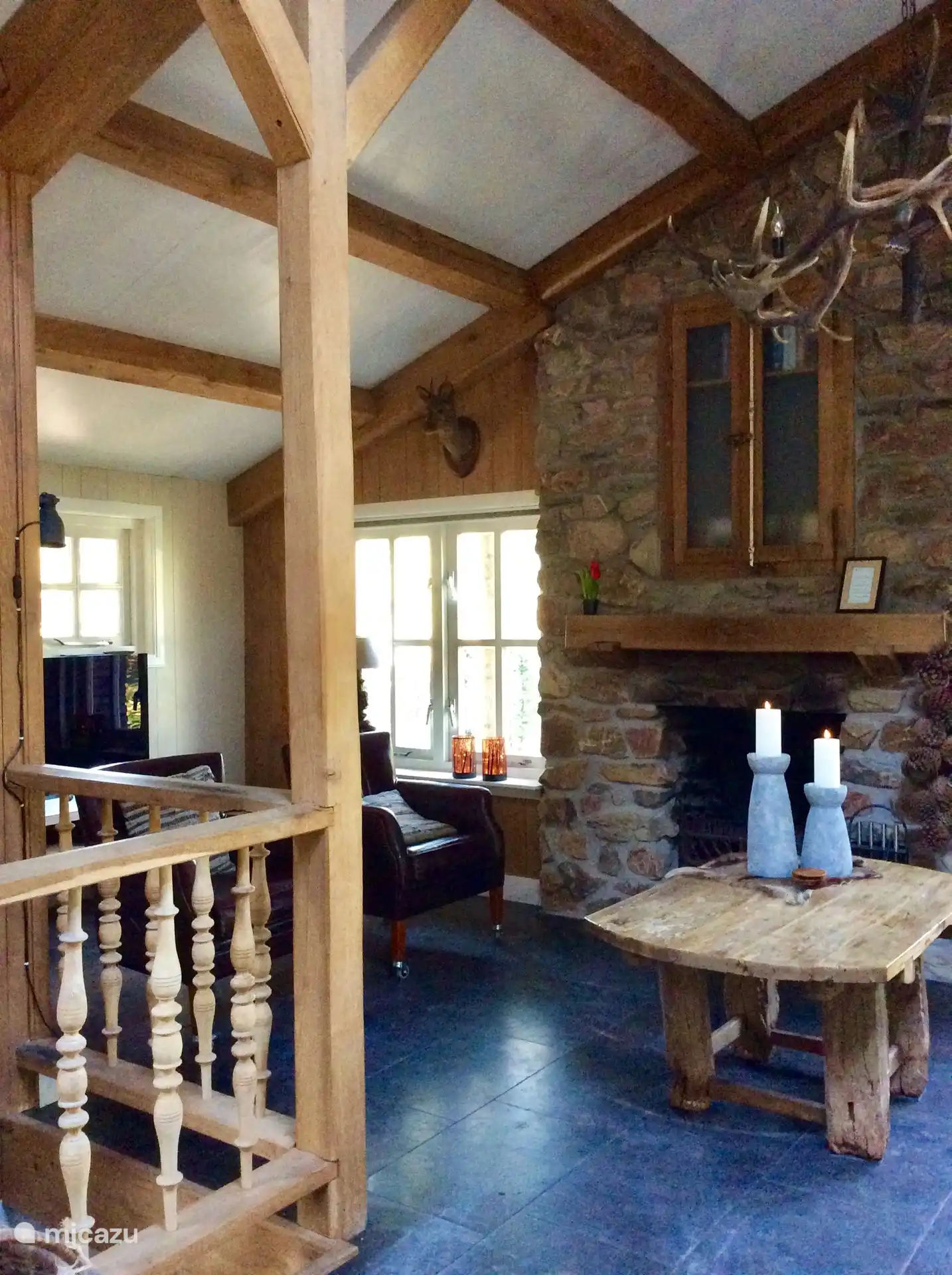 De woonkamer met zicht op de openhaard, links de televisie.