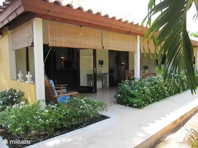 Vooraanzicht van appartement Kurason met een mooi terras en een klein stukje tropische tuin.