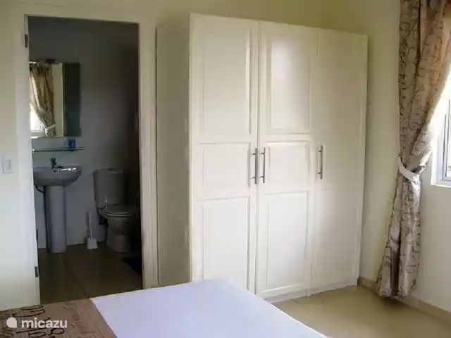Kas Mondi | Curaçao, Banda Ariba (est), Jan Thiel - villa La chambre principale avec la salle de bain attenante. Dans chaque chambre, vous trouverez une armoire trois pièces.