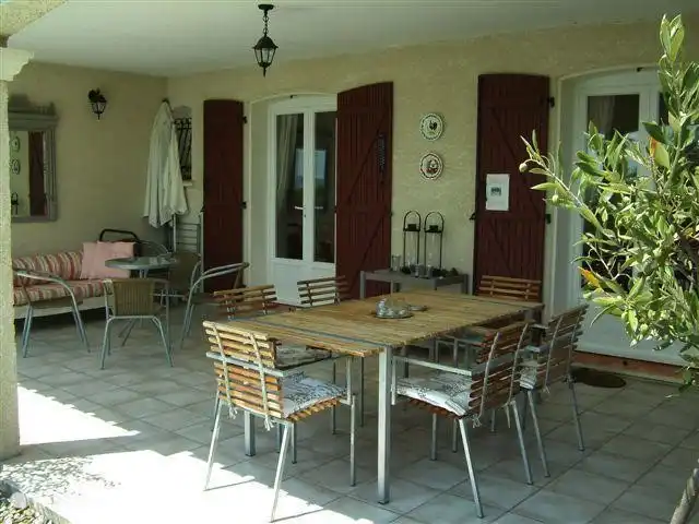 Le Chat Rouge 2026 avec 5** Confort | France, Hérault, Siran-Najac - villa La terrasse couverte avec table et chaises pour manger en plein air, ou tout simplement s'asseoir... ou s'allonger.