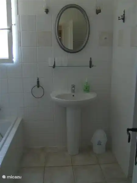 Spacious bathroom with bath, washbasin, walk-in shower and toilet.Here you will find also the washing machine.