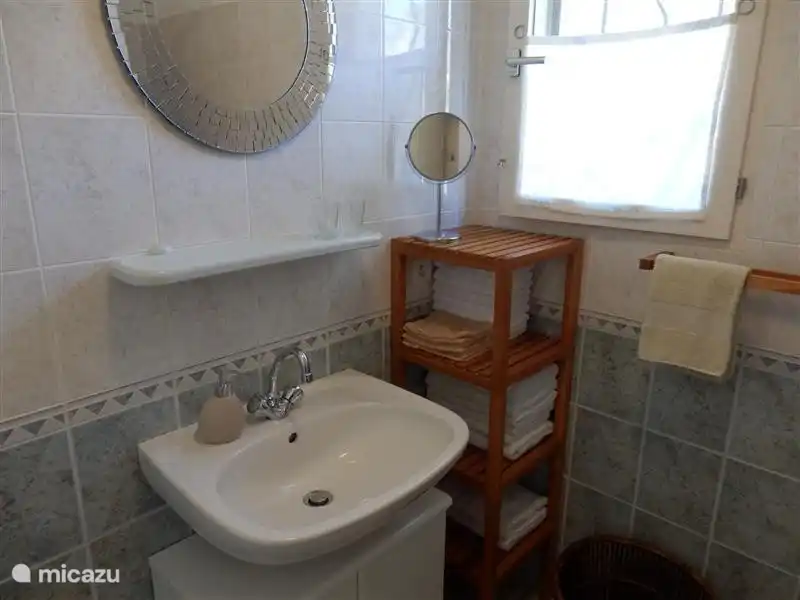 The bathroom has enough storage space for towels and toiletries.
