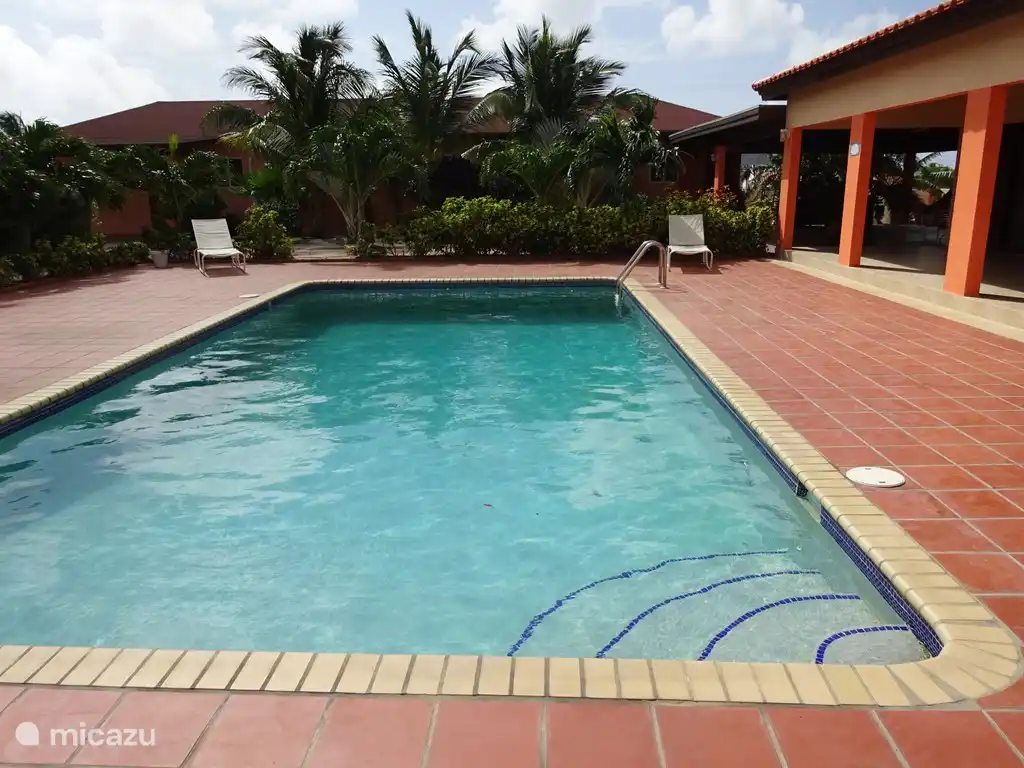 Door een volgroeide tuin van verschillende palmen en andere tropische planten en bomen worden de  appartementen en het huis van elkaar gescheiden.