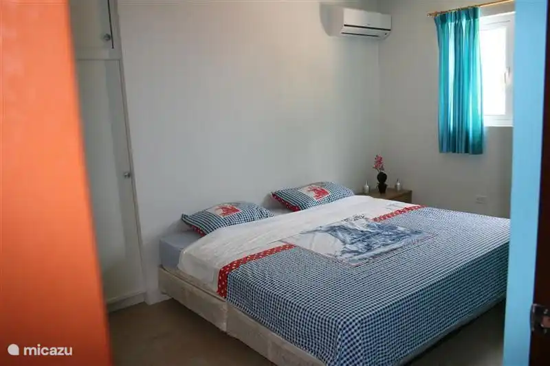 Schlafzimmer mit einem Kingsize-Bett mit Klimaanlage und einem großen Einbauschrank.