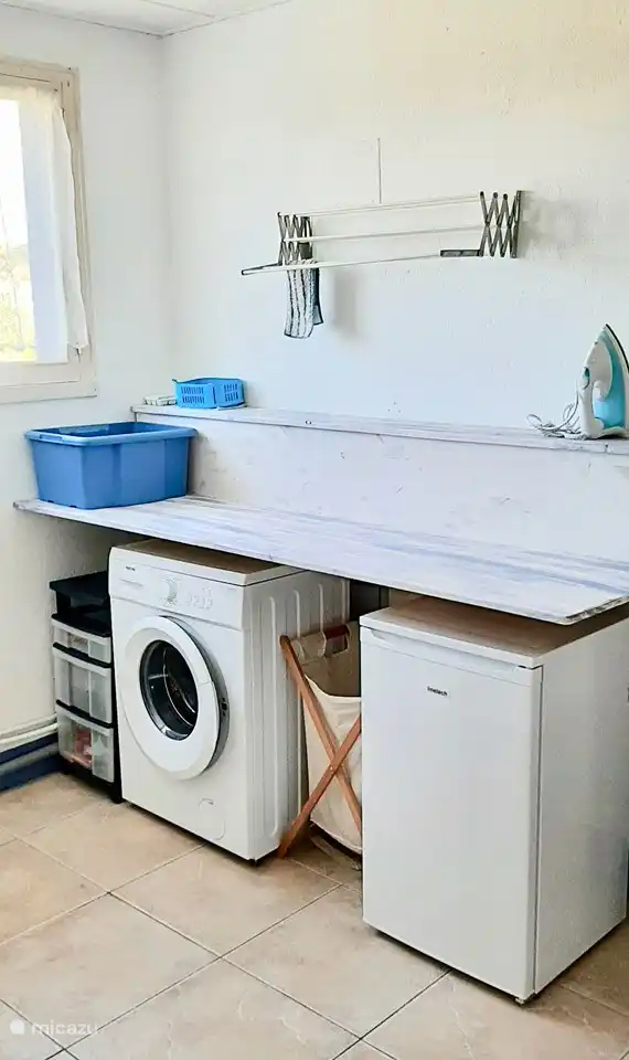 Bijkeuken met vriezer en wasmachine.